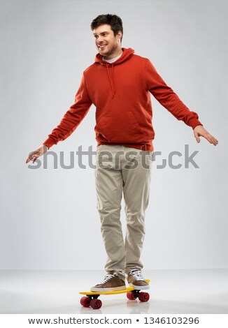 Foto stock: Smiling Young Man In Hoodie With Short Skateboard