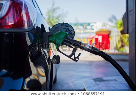 Foto d'archivio: Person With Gas Pump And Oil Barrel