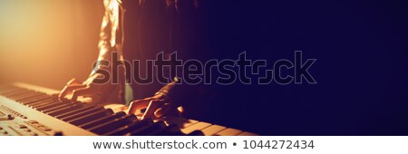 ストックフォト: Female Performer Playing Piano In Illuminated Nightclub