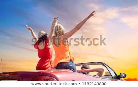 Zdjęcia stock: Happy Couple Driving In Convertible Car Over Sky