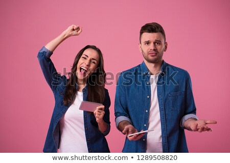 Stock photo: Young Man And Woman Playing Together Video Games Using Phones I