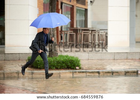 Foto stock: Asian Businessman Running In Rain