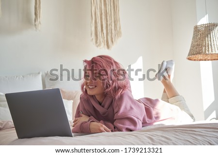 商業照片: Young Woman Watching A Funnt Movie On Tv In Bed