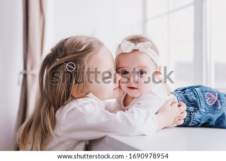 Stock fotó: Happy Little Girls Or Sisters Hugging At Home