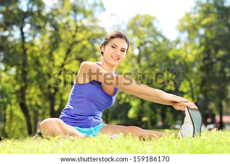 Foto stock: Young Female Athlete Excercising And Stretching In A Park