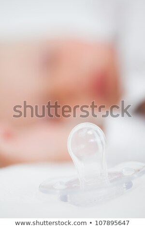 Foto d'archivio: Clear Pacifier Being Placed Next To A Baby In A Bedroom