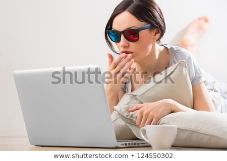 Stok fotoğraf: A Young Woman Lying On The Floor In Front Of Her Laptop With Cup