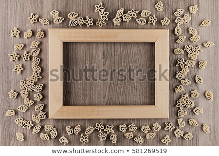 Stock photo: Italian Dry Sea Pasta On Beige Brown Wooden Board With Empty Copy Space As Decorative Frame Backgrou