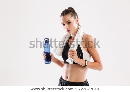 Zdjęcia stock: Tired Sportswoman With Towel On Her Neck Holding Water Bottle