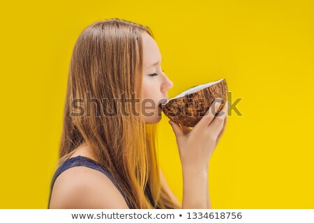 ストックフォト: Young Woman Drinking Coconut Milk On Chafrom Coconut On A Yellow Background