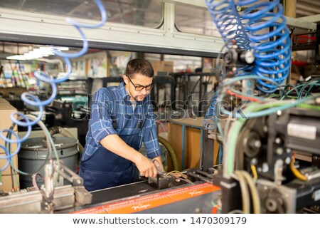 Young Mechanic Of Modern Production Factory Examining Industrial Machine 商業照片 © Pressmaster