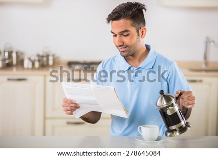 ストックフォト: Morning News Handsome Young Man Drinking Coffee At Home In The Loft Kitchen