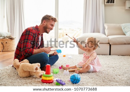 [[stock_photo]]: Father Playing With Baby Daughter On Sofa At Home