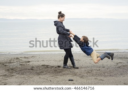 Boy Enjoying The Rain And Having Fun Outside On The Beach A Gray Rainy Foto d'archivio © Lopolo