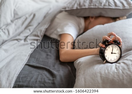 Stock fotó: Unhappy Woman Awaked By Her Alarm Clock In Her Bedroom