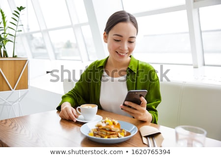 Stockfoto: Smiling Asian Woman Having Pancakes For Breakfast