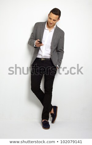 Foto stock: Smiling Businessman Reading Text Message Against A White Background