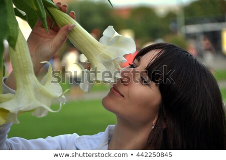 Stok fotoğraf: Young Woman Enjoying Lily Flower Scent