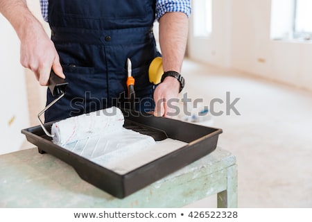 Foto stock: Close Up Of Mans Hands Using Paint Roller