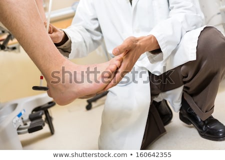 Stock photo: Doctor Examining Reflexes Of Patient Knee