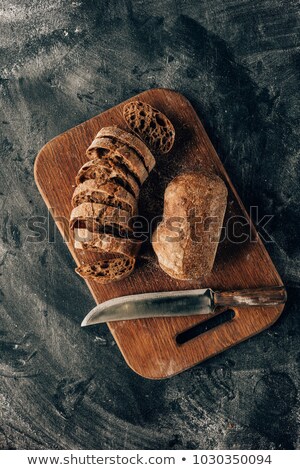 Zdjęcia stock: Top View Of Arranged Pieces Of Bread On Cutting Board With Knife On Dark Surface With Flour