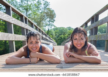 Stockfoto: Two Friends Lying Together On Wooden Bridge