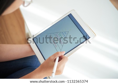 Foto stock: Female Writing Hierarchy Of Needs On Tablet