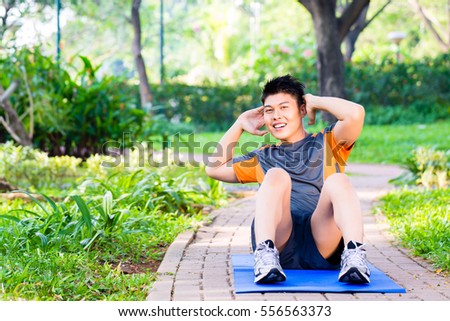 Athletic Chinese Man At The City Park Doing Sit Ups Foto d'archivio © Kzenon
