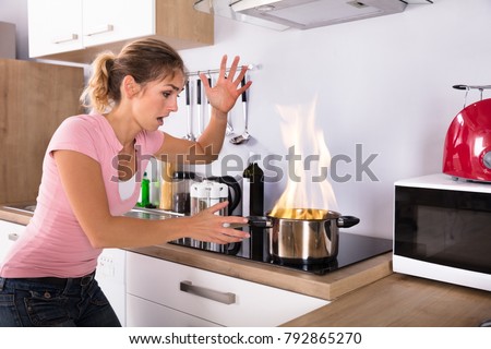 Stock fotó: Young Woman Looking At Burning Cooking Pot