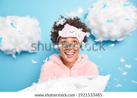 Stockfoto: Pretty Young Girl Wearing Pajamas Holding A Feather