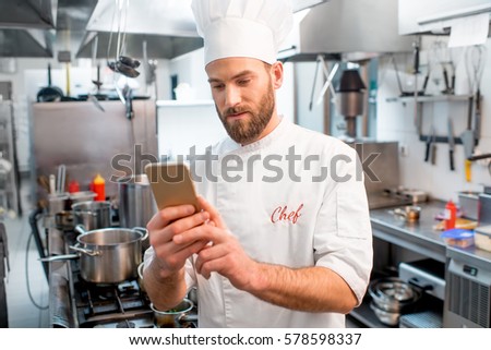 Stock photo: Male Chef Using Mobile Phone In The Kitchen