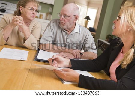Foto stock: Senior Adult Couple Going Over Documents In Their Home With Agen