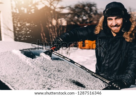 Foto d'archivio: Man Brushing The Snow Off The Windshield Of His Car
