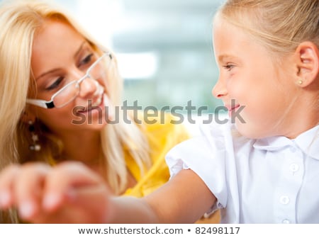 Imagine de stoc: Teacher Helps To Little Girls To Make An Exercises In Classroom