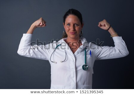 ストックフォト: Young Female Looking At Her Biceps Against A White Background