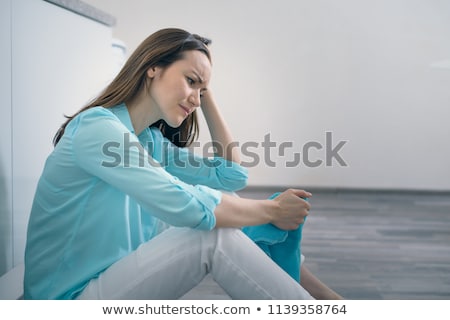Foto d'archivio: Depressed Young Woman Sitting On The Kitchen Floor