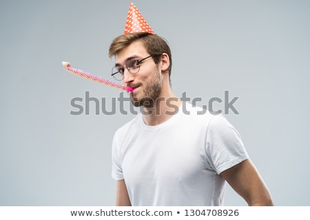 Stock photo: Handsome Man With Party Hat Blowing In Whistle