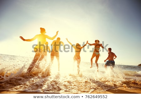 Foto stock: Four People Running Into The Water
