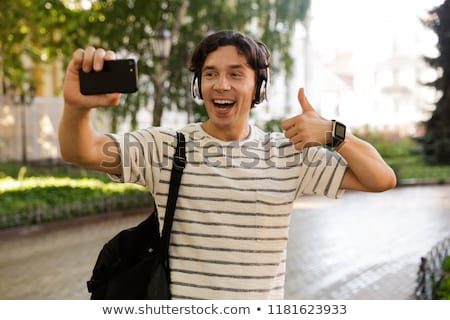 Zdjęcia stock: Excited Casual Man Carrying Backpack At The City Street