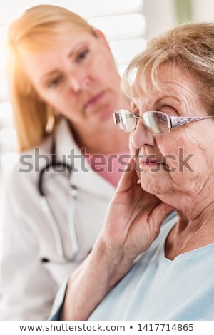 Stok fotoğraf: Melancholy Senior Adult Woman Being Consoled By Female Doctor Or