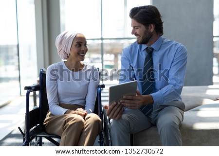 Stok fotoğraf: Front View Of Handsome Disabled Male Executive Talking On Mobile Phone In Office With Coworkers In T