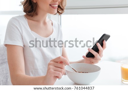 Stock fotó: Cropped Photo Of Young Brunette Girl In White Tshirt Using Smart