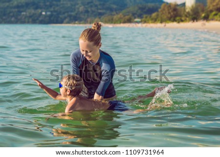 Сток-фото: Woman Swimming Instructor For Children Is Teaching A Happy Boy To Swim In The Pool