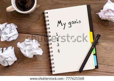 Stok fotoğraf: Goals As Memo On Notebook With Idea Crumpled Paper Cup Of Coffee
