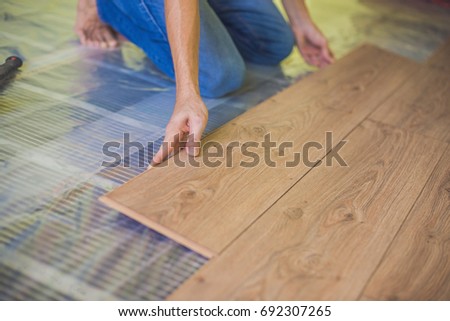 Stok fotoğraf: Man Installing New Wooden Laminate Flooring Infrared Floor Heating System Under Laminate Floor