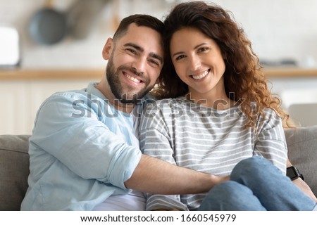 Zdjęcia stock: Loving Spouses Pose In Rented Apartment Woman Relaxes On Couch With Pet Speaks Via Modern Smartpho