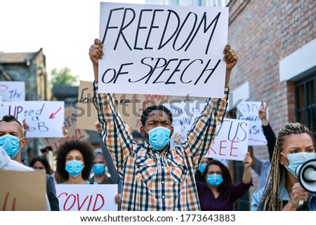 ストックフォト: Man Activist In A Protective Mask Holding A Placard Fight For Human Rights Protest Against Violenc
