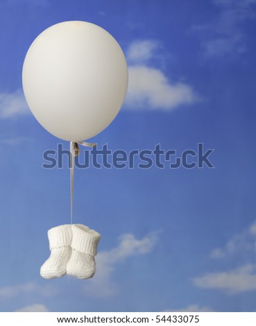 Foto stock: Oncepto · de · nacimiento · Botines · de · bebé · azul · colgando · de · un · globo · en · el