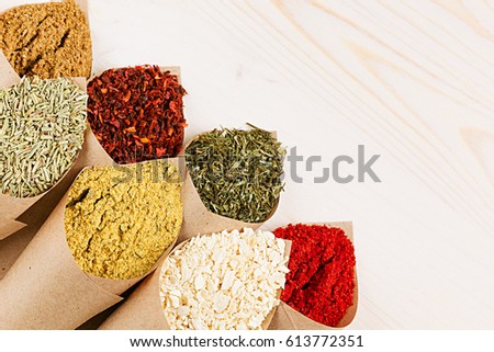 Сток-фото: Various Powder Spices Close Up In Paper Corner On White Wooden Board With Copy Space