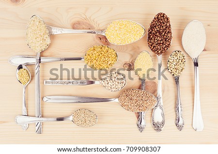 Foto d'archivio: Decorative Background Of Assortment Groats Grain In Silver Spoons On Wood Plank Healthy Food Backgr